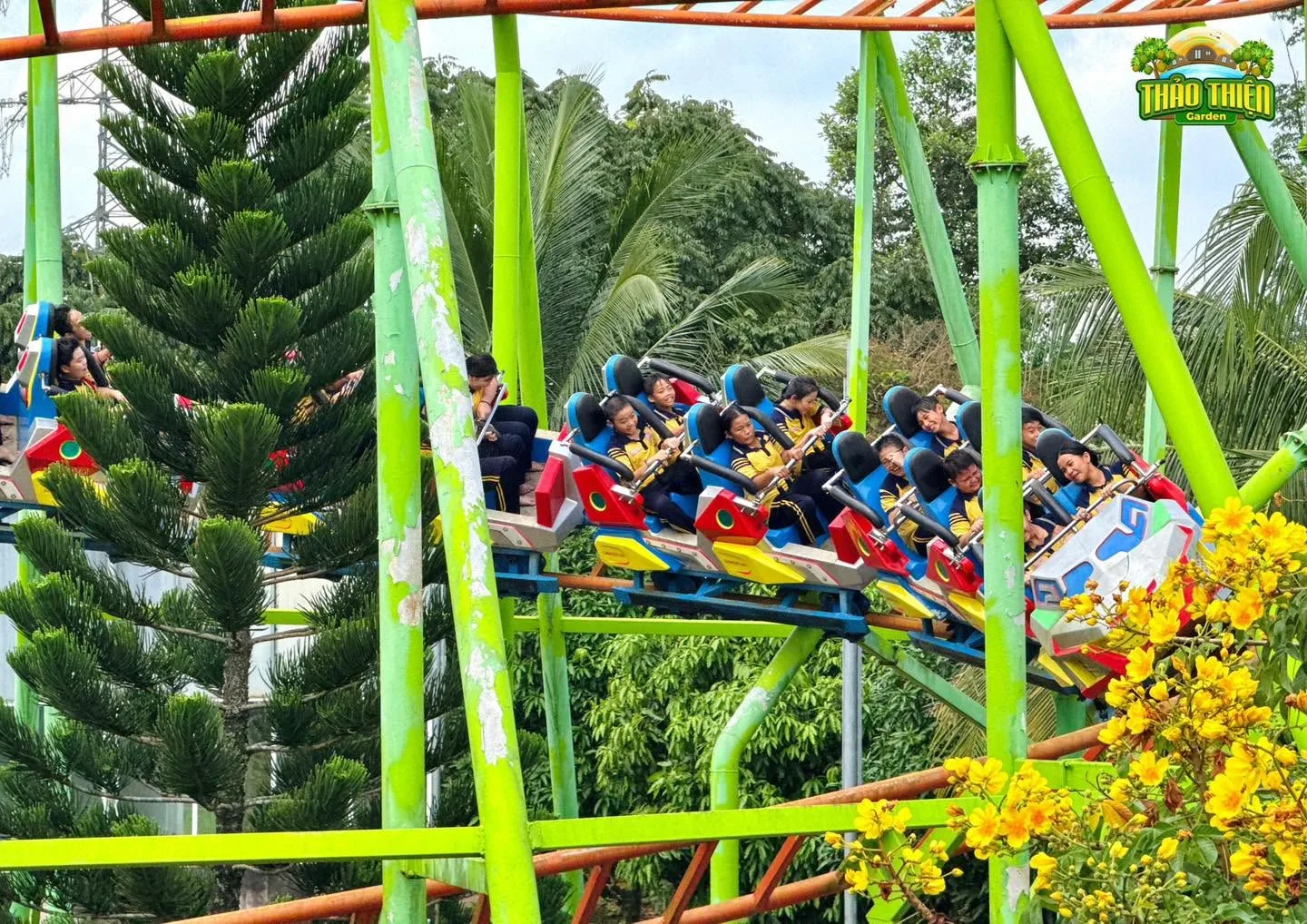 Tàu lượn siêu tốc đường ray xanh lá giữa vườn cây